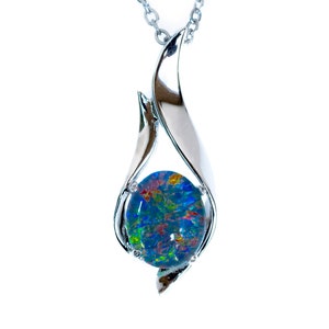 May include: A silver chain necklace with a pendant featuring a blue opal gemstone set in a silver flame-shaped design.
