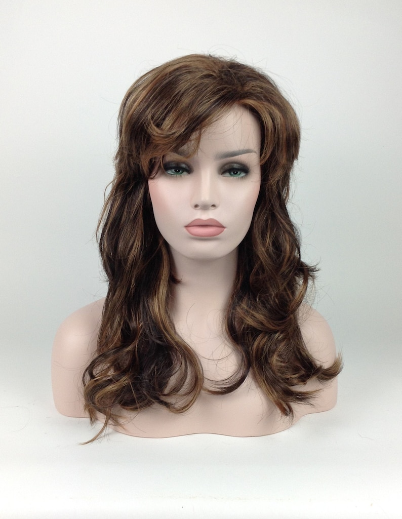 May include: A long, wavy brown wig with blonde highlights. The wig is styled with a side parting and loose curls.