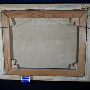 May include: The back of a wooden picture frame with a canvas stretched inside. The frame is made of dark wood and has a simple design. The canvas is a light brown color and is attached to the frame with staples. There is a small, blue and white matchbook on the bottom of the frame that says "Starlight".