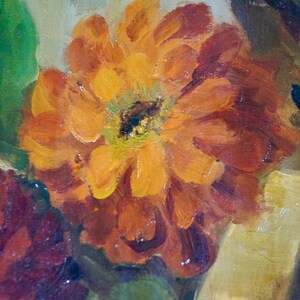 May include: A close-up of a painting featuring a vibrant orange flower with red and yellow hues. The flower is surrounded by green leaves and other flowers in shades of red and brown.