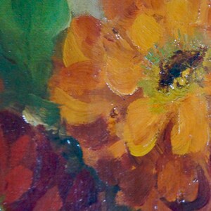 May include: Close-up of a painting of a flower with orange, yellow, and red petals. The flower is in focus, and the background is blurred.