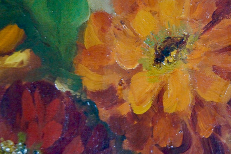 May include: Close-up of a painting of a flower with orange, yellow, and red petals. The flower is in focus, and the background is blurred.