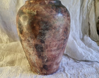 Może przedstawiać: Brązowy ceramiczny wazon z powierzchnią marmurkową i fakturowaną. Wazon ma zaokrągloną podstawę i lekko rozszerzający się otwór.