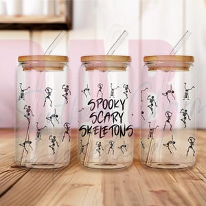 May include: Three glass jars with bamboo lids and clear drinking straws. The jars are decorated with black skeleton figures and the text "Spooky Scary Skeletons".