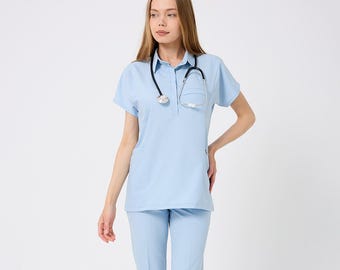 May include: Light blue medical scrubs set, including a short-sleeved top with a pocket and matching pants. A black stethoscope hangs around the neck. The outfit is paired with white sneakers.