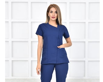 May include: A navy blue medical scrub top and pants set. The top has a V-neck and a single pocket on the left side. The pants have two pockets on the front.