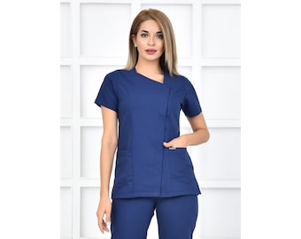 May include: A navy blue medical scrub top with a short sleeve and a diagonal zipper closure. The top has two pockets on the front.