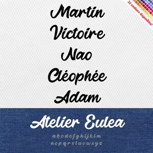 以下が含まれることがあります： 「Atelier Eulea」という名前の書体で、筆記体スタイルです。書体は白地に黒で表示され、下部に青いデニムの背景があります。アルファベットは書体名の下にグレーで表示されています。