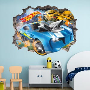 Könnte beinhalten: Ein Wandtattoo mit einem blauen Rennwagen, der durch eine Wand bricht, und einem gelben Rennwagen im Hintergrund. Das Tattoo enthält den Text "Your Name" auf einem Banner. Die Autos haben Flammen und sind von orangefarbenen Kegeln umgeben.