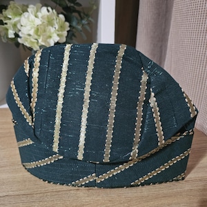 May include: A dark green and gold striped hat with a pointed top and a curved brim.