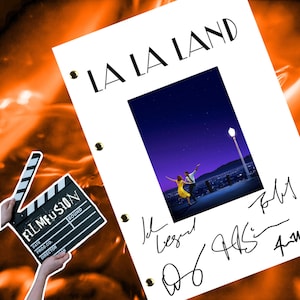 May include: A white script for the movie "La La Land" with a photo of the main characters dancing on a rooftop overlooking a city skyline. The script is signed by the director, Damien Chazelle, and the actors, Emma Stone and Ryan Gosling.