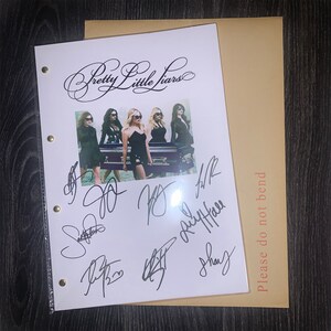 Puede incluir: Una hoja de papel blanca con las palabras "Pretty Little Liars" escritas en cursiva en la parte superior. Hay una foto de cuatro mujeres con vestidos negros de pie frente a un ata&uacute;d. El papel est&aacute; firmado por las cuatro mujeres. El texto "Please do not bend" est&aacute; escrito en el lado derecho del papel.