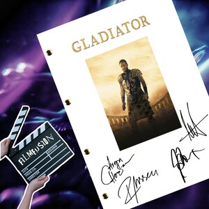 May include: A white framed movie script for the film "Gladiator" with a photo of Russell Crowe as Maximus Decimus Meridius. The script is signed by Russell Crowe, Ridley Scott, and D.J. Caruso.