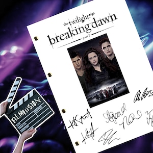 May include: A white script with the text "the twilight saga breaking dawn part 2" in black. A black and white photo of the main characters from the movie is below the text. The script is signed by the actors.