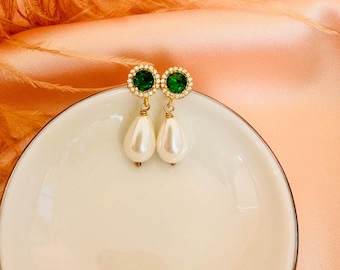 May include: A pair of gold earrings with green gemstone accents and pearl drops.