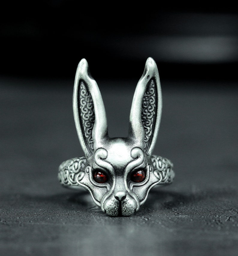 May include: A silver ring with a detailed rabbit head design. The rabbit has red eyes and intricate details on its ears and face.