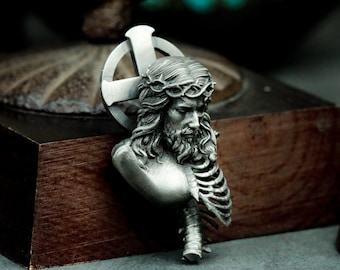 May include: A silver pendant depicting a bust of Jesus Christ with a crown of thorns and a ribcage, set against a cross.