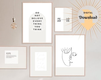 May include: A set of four printable wall art prints in black and white. The prints feature minimalist line art designs, including a face, a brain, and the words "Do not believe every thing you think". The prints are framed in a light wood frame and are displayed on a wall with a wooden shelf underneath.