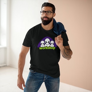 May include: A black t-shirt with a purple and green alien graphic and the text "workshop".