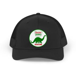 May include: Black trucker hat featuring a green and white Sinclair Dino logo. The logo includes a green dinosaur silhouette and the words "Sinclair DINO" and "GASOLINE" in a circular design. The hat has a mesh back.