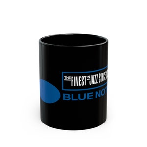 Może przedstawiać: Czarny kubek ceramiczny z niebieskim kółkiem i białym tekstem "The Finest in Jazz Since 1939 Blue Note"