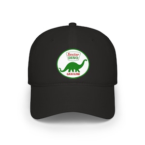 May include: Black baseball cap featuring the Sinclair Dino logo. The logo is a green dinosaur inside a white circle with the words "Sinclair DINO" and "GASOLINE" in green text. The cap has a curved brim and a structured fit.
