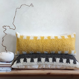 May include: Two decorative throw pillows with geometric patterns. The top pillow is yellow with white accents, and the bottom pillow is gray with white accents.