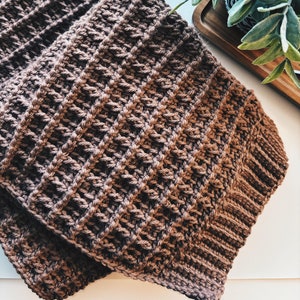 May include: A brown crocheted scarf with a ribbed texture.