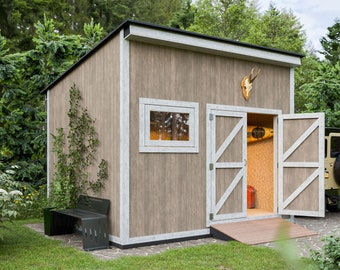 Puede incluir: Un cobertizo de madera con techo negro, molduras blancas y puertas dobles. En el interior, se ve un kayak y un contenedor rojo. Una cornamenta de ciervo cuelga sobre las puertas. Un vehículo con rueda de repuesto está aparcado cerca.
