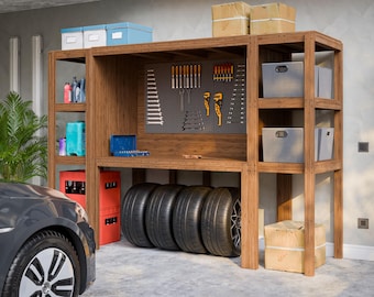 May include: A wooden shelving unit with multiple shelves and a work surface. The shelves are filled with various items, including tools, storage bins, and tires. The unit is in a garage setting.