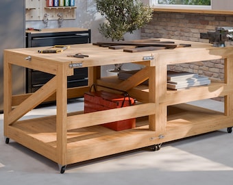 May include: A large, light-coloured wooden workbench with multiple shelves and a red toolbox. The workbench has a vice attached and is on wheels. Tools are visible on the work surface. The workbench is approximately 152 cm long.