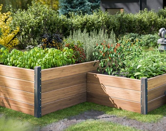 May include: Two wooden raised garden beds with a variety of plants growing in them. The beds are made of brown wood with black metal accents. The beds are set on a green lawn.