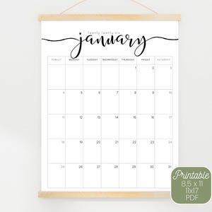 May include: A white 2025-2026 18-month calendar with the month of January displayed. The calendar is held by a wooden frame. The text "twenty twenty-six" and "january" are written in a cursive font. The calendar is available in 8.5 x 11 and 11x17 PDF formats.