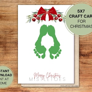 May include: A printable 5x7 craft card featuring a green footprint design with the text "Merry Christmas Mistletoes". The card is decorated with a red bow and holly.