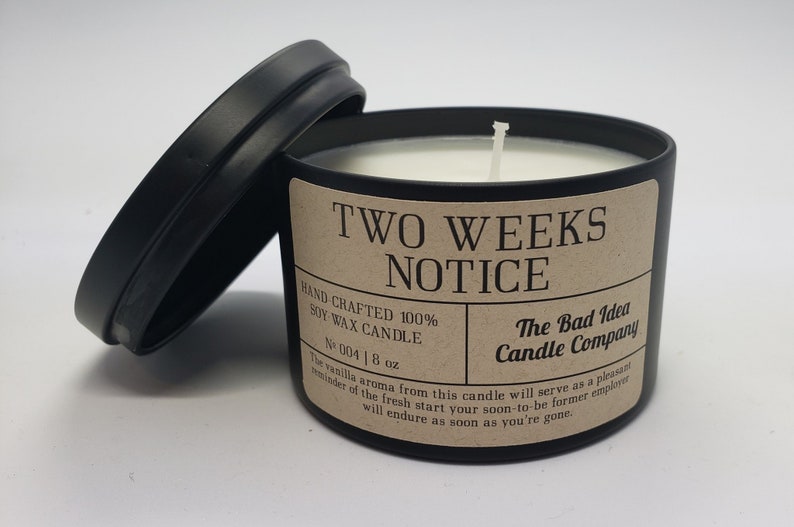 May include: A black candle jar with a brown label that reads "Two Weeks Notice" and "The Bad Idea Candle Company". The candle is soy wax and is 8 ounces.