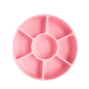 May include: A pink silicone divided plate with six sections. The plate is round and has a raised edge.