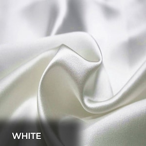 Peut inclure: Tissu de satin blanc avec une texture lisse et soyeuse. Le tissu est drapé et plié, créant des courbes et des plis doux.