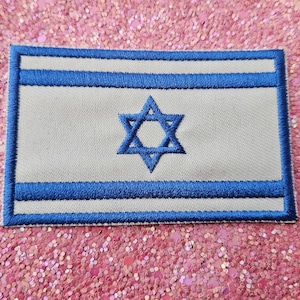 Op de afbeelding: Geborduurde patch met de vlag van Israël. De patch heeft een witte achtergrond met twee horizontale blauwe strepen en een blauwe Davidster in het midden. De randen zijn blauw omlijnd.