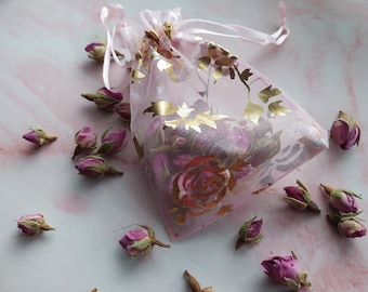 Geurzakjes met rozengeur en geparfumeerde roze rozenknoppen en rozenblaadjes in geurzakje