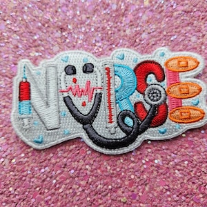 Puede incluir: Parche bordado con la palabra "NURSE" en blanco, con símbolos médicos. El diseño incluye una jeringa, un estetoscopio, un termómetro y vendas. El parche está sobre un fondo rosa brillante.