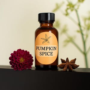 Könnte beinhalten: Eine braune Glasflasche mit schwarzem Deckel und einem orangefarbenen Etikett mit der Aufschrift "PUMPKIN SPICE". Eine dunkelrote Blume und ein Sternanis befinden sich neben der Flasche. Der Hintergrund ist hellbeige.