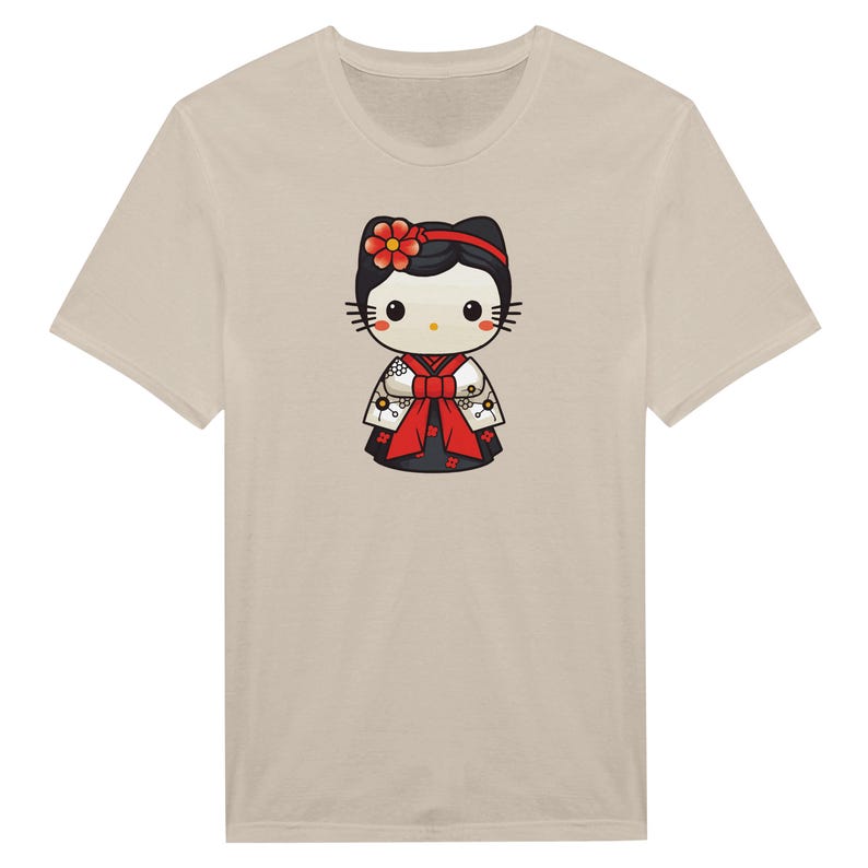 May include: Beige t-shirt featuring a cartoon character in a Japanese kimono. The character has a black head with a red flower, black whiskers, and a red and white kimono with a red bow. The t-shirt is a neutral color.