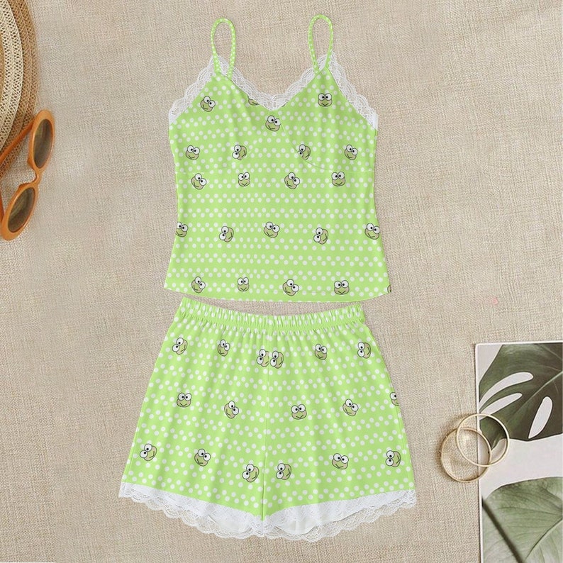 May include: Green and white pajama set with a frog print and lace trim. The top is a spaghetti strap tank top and the bottoms are shorts.