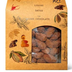 May include: A tan box of dates in dark chocolate, with illustrations of cocoa pods and leaves. The text "LUXURY DATES in DARK CHOCOLATE" is printed on the front. A clear window shows the chocolate-covered dates. The box contains 700g of product.
