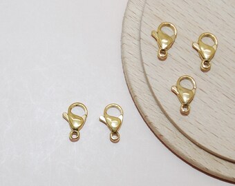 May include: Five gold-toned lobster clasps, a type of fastener used in jewelry making.
