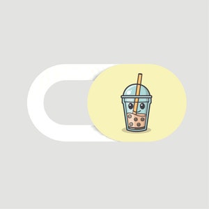May include: A light yellow webcam cover with a white slider. The cover features a cartoon illustration of a smiling bubble tea drink with a straw. The bubble tea is in a clear cup with brown tapioca pearls.