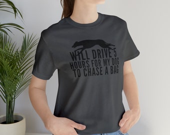 May include: A dark gray t-shirt with a black silhouette of a dog running and the text "WILL DRIVE 5 HOURS FOR MY DOG TO CHASE A BAG".