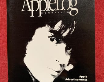 May include: Black and white magazine cover with the title "AppleLog Companion" and the text "Volume One - Number One Fall 1991". The cover features a black and white photo of a person's face.
