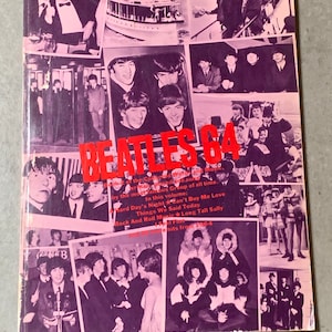 May include: A pink and white magazine cover with a collage of photos of the Beatles. The cover features the title "Beatles 64" in red and white letters. The text below the title reads "Book 2 of the Collected Words and Music written, recorded and sung by the most famous Group of all time. In this volume: Hard Day's Night, Can't Buy Me Love, Things We Said Today, Rock and Roll Music, Long Tall Sally and I Feel Fine"