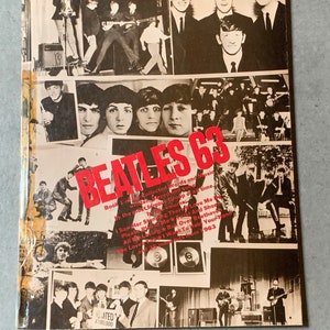 May include: A black and white photo book cover with a collage of images of the Beatles. The title "Beatles 63" is in red and white letters. The book includes a list of songs from 1963, including "Love Me Do", "Please Please Me", "Twist and Shout", and "All My Loving".